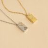 deux colliers avec une enveloppe en pendentif, fermée, contenant un message gravé à l'intérieur