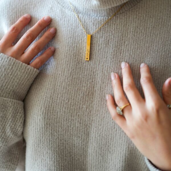 Mannequin portant un collier avec une barre contenant gravure