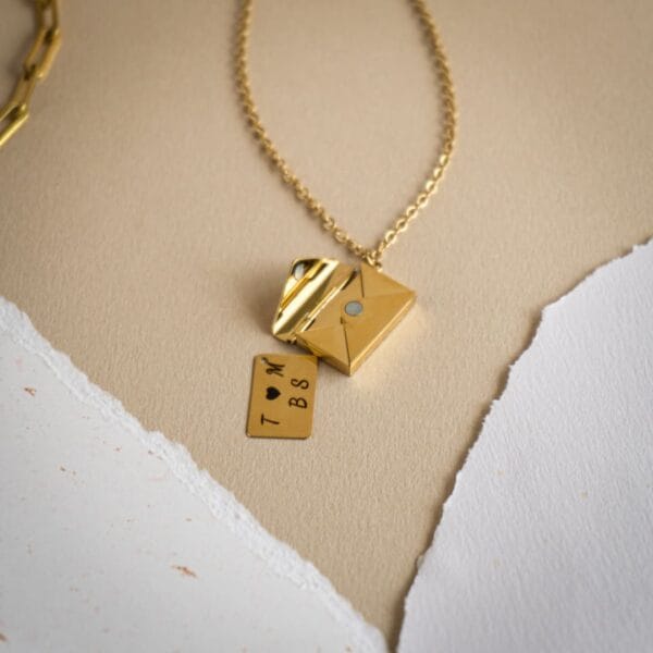 chaine avec une lettre en pendentif contenant une plaque gravé d'un message d'amour