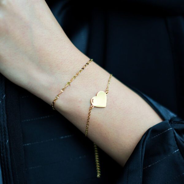 un bracelet avec un coeur à personnaliser et un autre simple et raffiné, au poignet