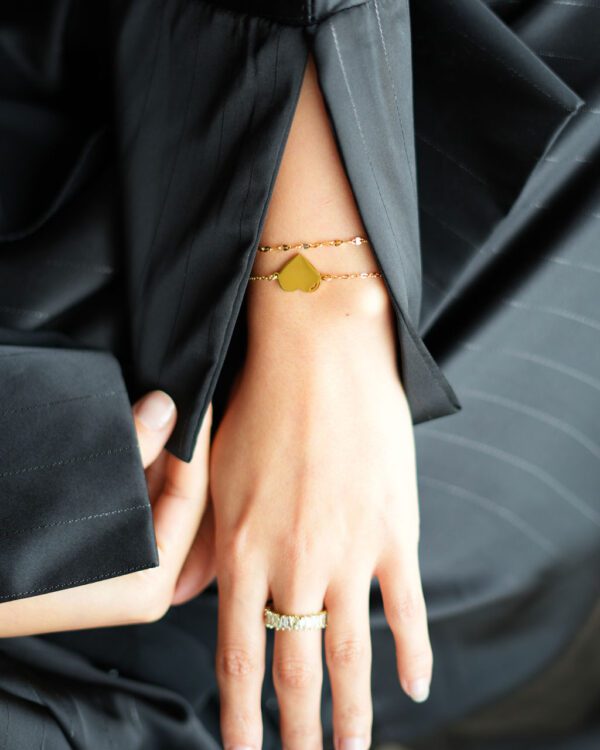 un bracelet avec un coeur à personnaliser et un autre simple et raffiné, au poignet