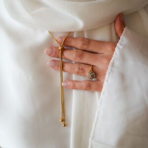 Collier à fermeture coullisante, doré, en acier, porté et exposé avec la main (bague au doigt)