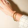 Lot de 4 bracelets couleur or au poignet, main en l'air