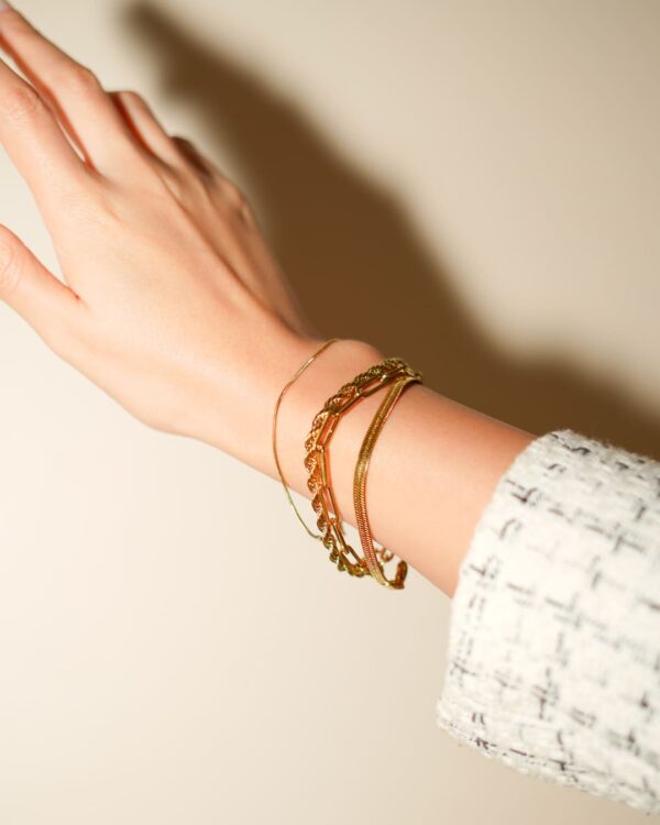 Lot de 4 bracelets couleur or au poignet, main en l'air