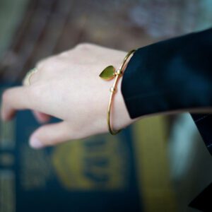 bracelet rigide, doré, avec un coeur à personnaliser, tenu au poignet