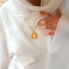 Medaillon en acier vierge porté sur voile blanc
