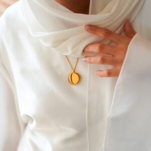 Medaillon en acier vierge porté sur voile blanc