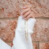 Collier doré ljubezen porté à la main