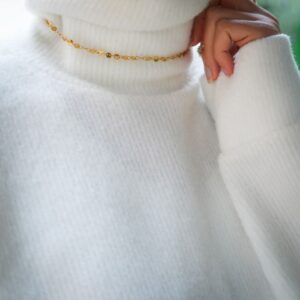 Collier ljubezen porté sur un col roulé blanc