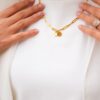deux pendentif sur le bijou à anneaus - collier - porté sur vêtement blancs