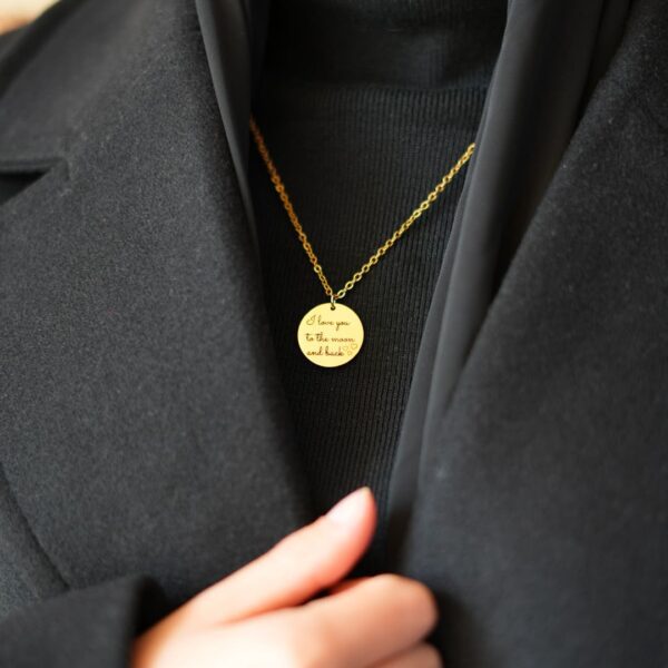 Collier personnalisé avec I love you to the moon and back, gravé, porté sur vêtement noirs. Bijou personnalisé