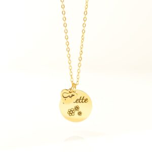 Bijou en acier personnalisé avec deux pendentifs : un gros disque gravé avec 3 petites fleurs et un petit coeur sur lequel est gravé Hubb - Amour en arabe