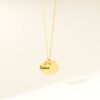 Bijou couleur or avec deux pendentifs : un rond martelé et un petit coeur lisse gravé