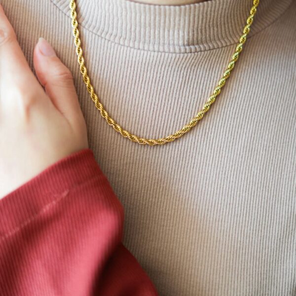 Collier doré torsadé porté au cou