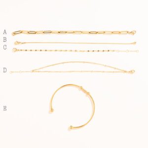 Lot de 5 bracelets dorés, posés sur fond blanc, numéroté de A à E