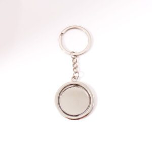 Porte clé argent, sur fond blanc. Disque tournoyant sur lui même à personnaliser avec gravure
