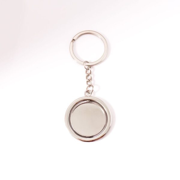 Porte clé argent, sur fond blanc. Disque tournoyant sur lui même à personnaliser avec gravure