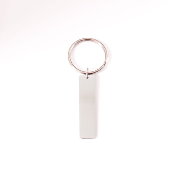 porte clé argenté à personnalisé posé sur fond blanc