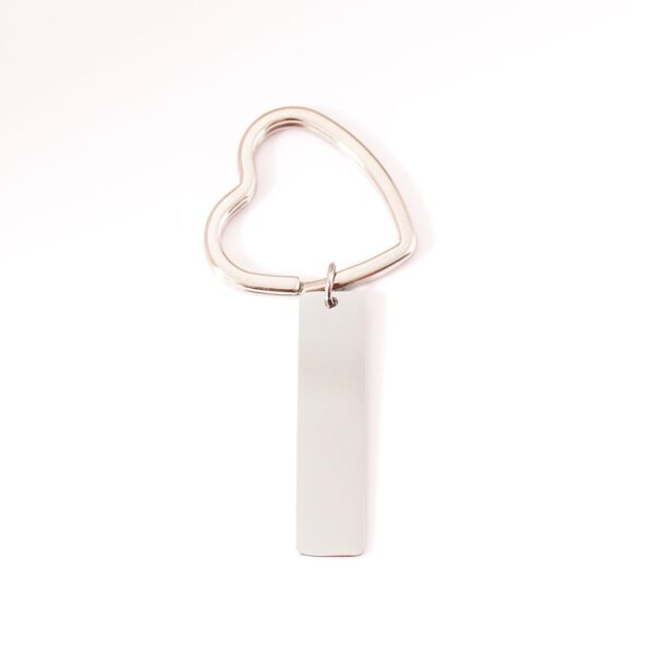 porte clé argenté à personnalisé posé sur fond blanc, anneaux en coeur