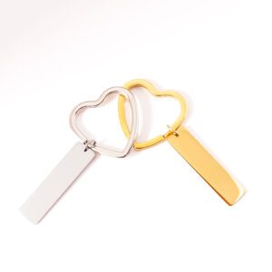 deux portes clés doré et argenté, à personnaliser, sur fond blanc. Anneau en forme de coeur